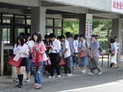 受付で資料やうちわを受け取る参加者
